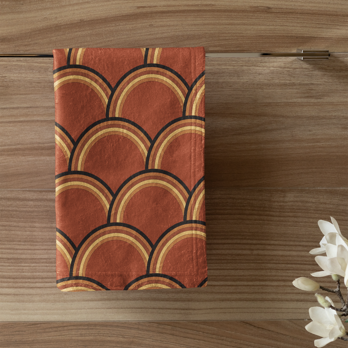 Decorative towel with geometric pattern on a wooden wall above a white cabinet with a candle and plant.