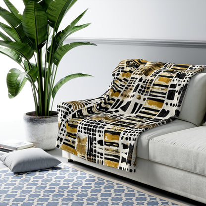 Patterned blanket draped over a sofa in a living room with a plant and rug.