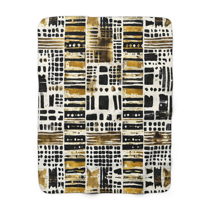 Patterned blanket with black, gold, and white design on a white background