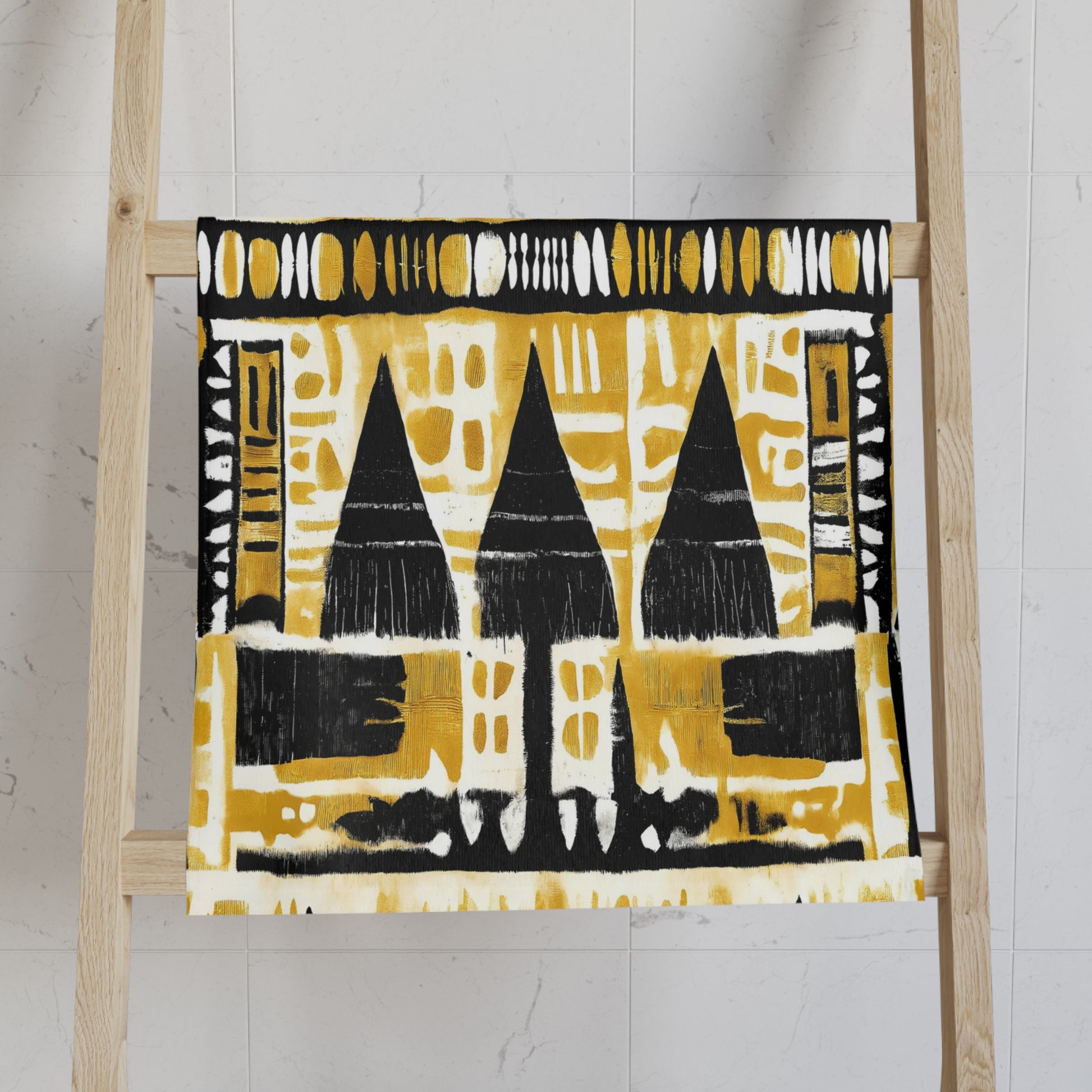 Mudcloth towels with black and yellow pattern on a wooden ladder against a white wall