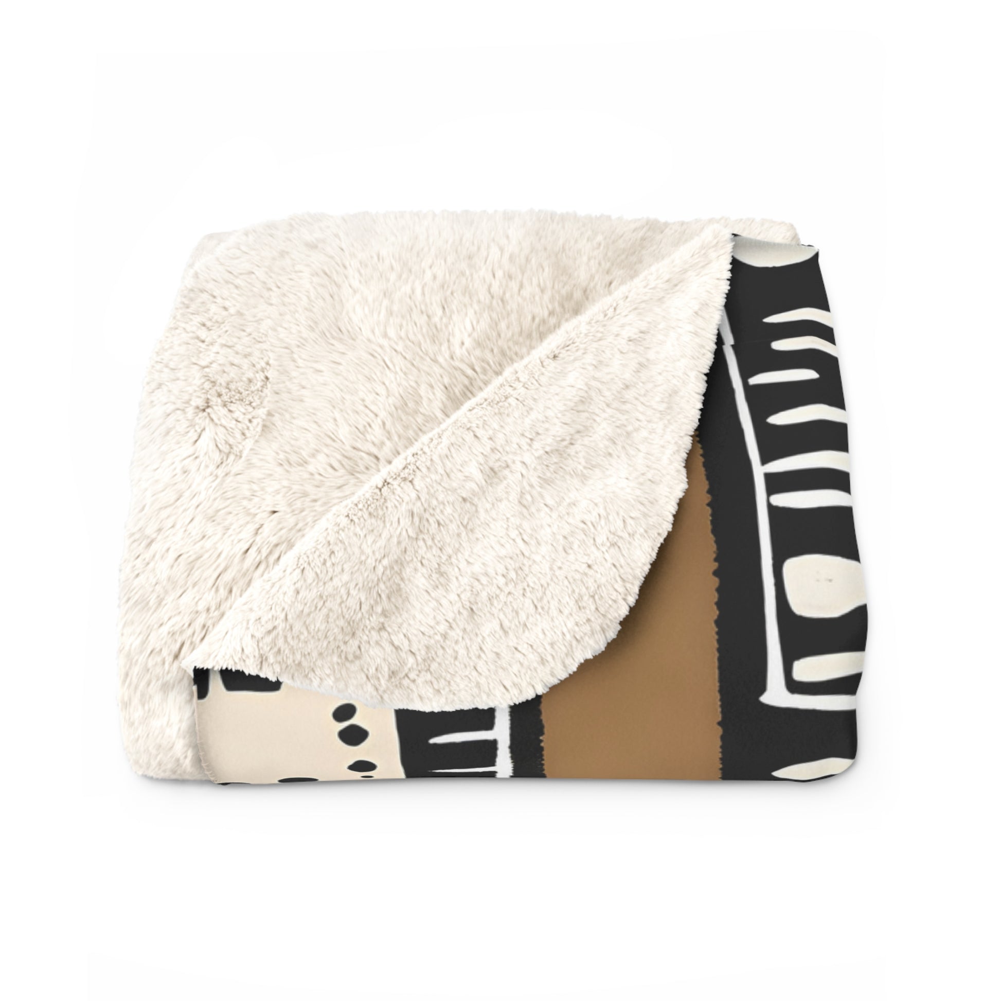 Folded blanket with white sherpa side and black and white patterned side on a white background