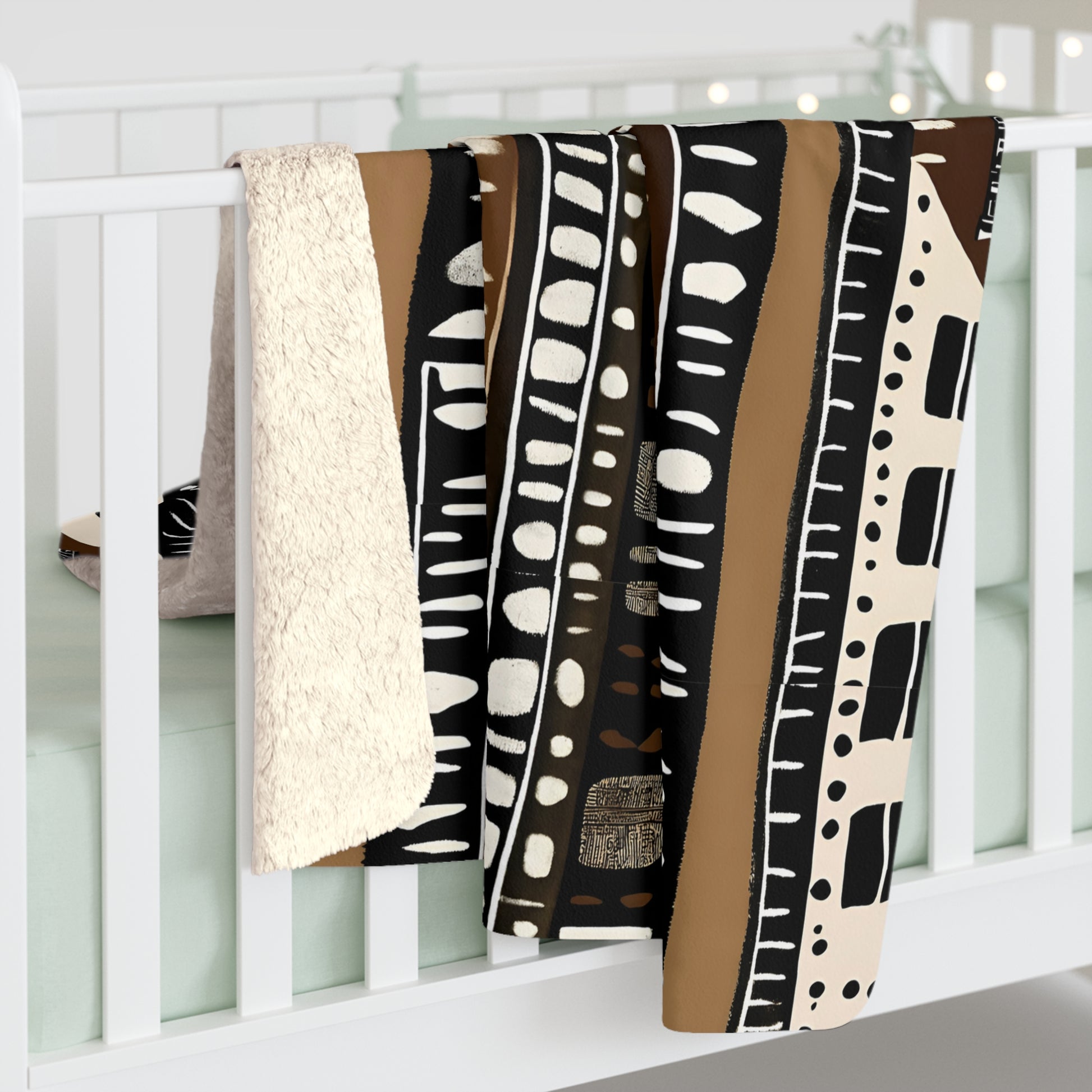 Mudcloth Patterned blanket draped over a white crib