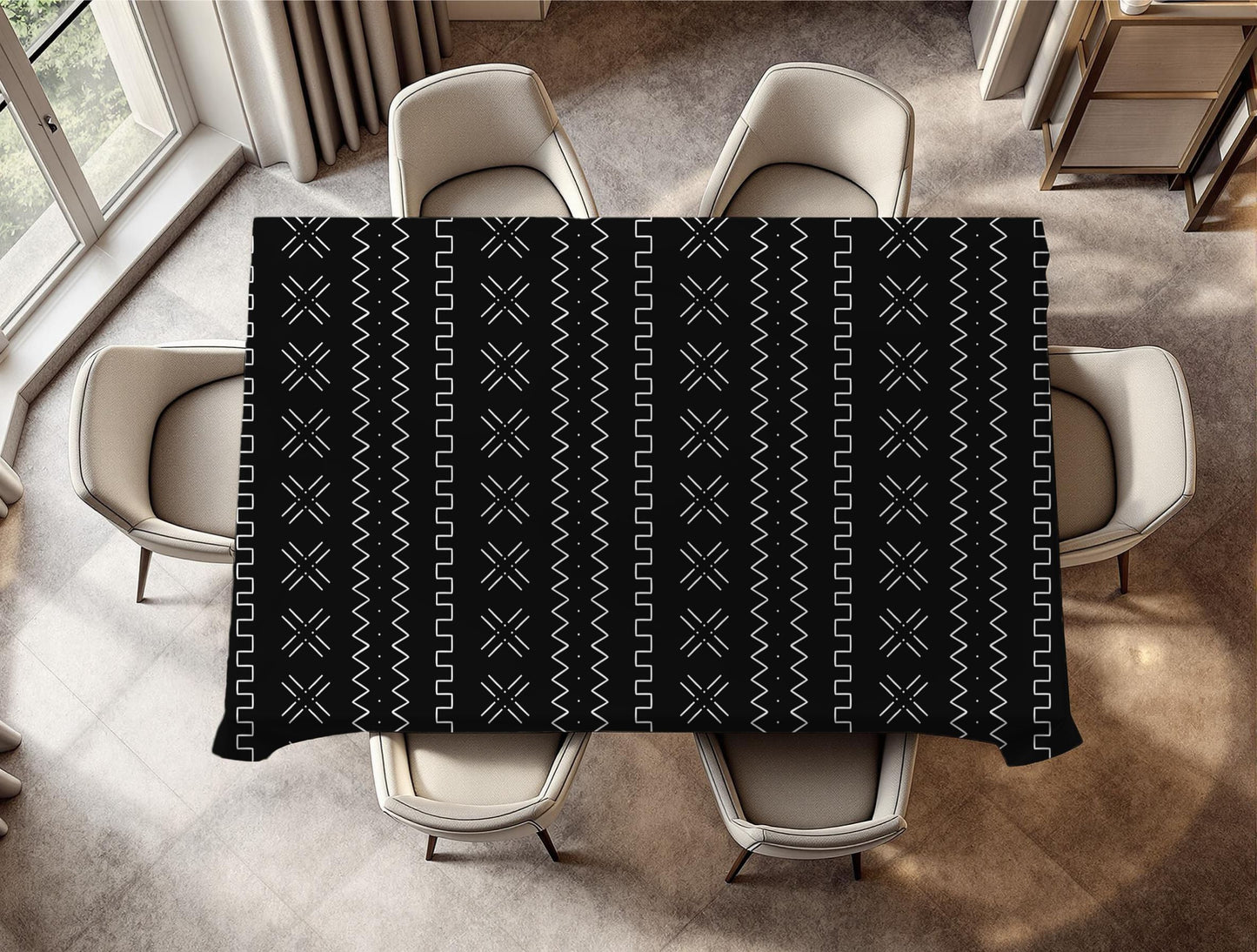 Black mudcloth patterned tablecloth on a dining table with chairs in a room.