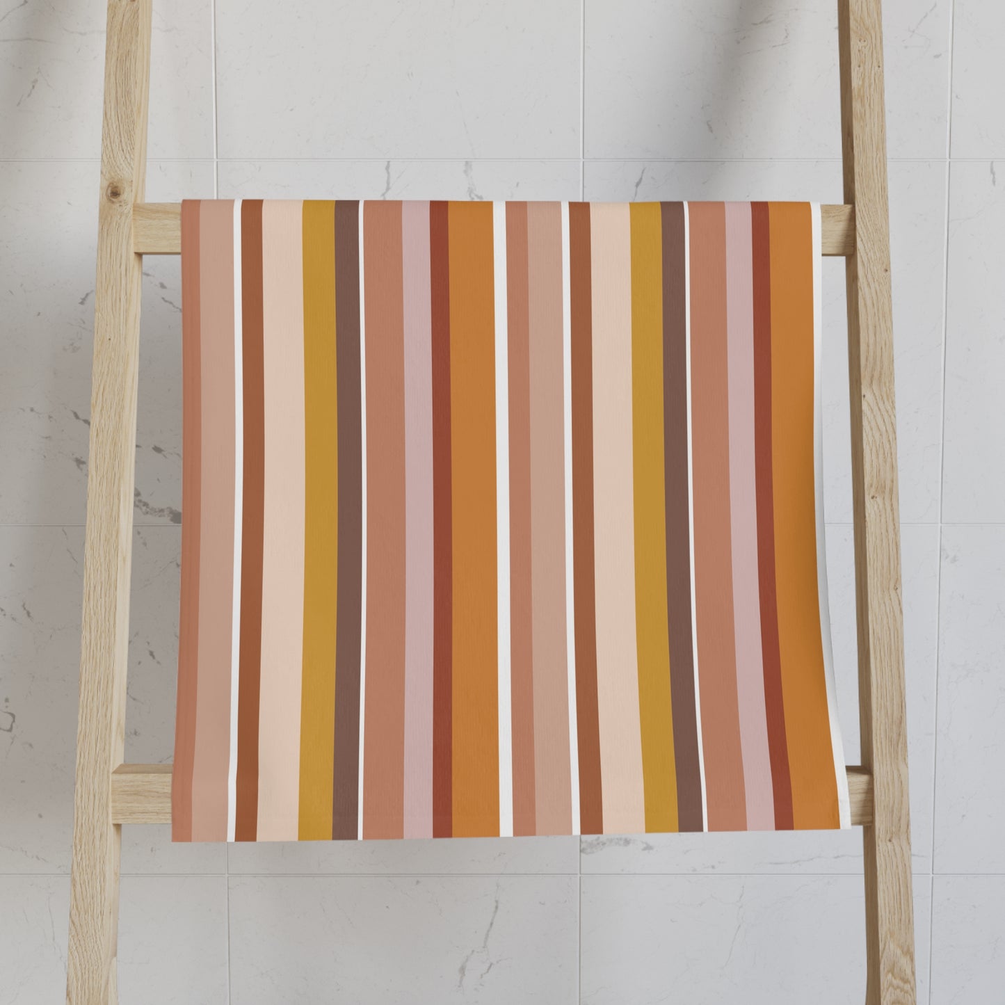 Striped towel on a wooden ladder against a white wall