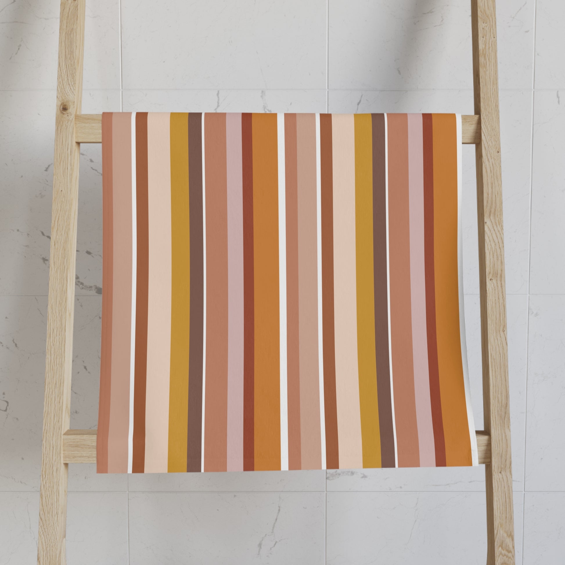 Striped towel on a wooden ladder against a white wall