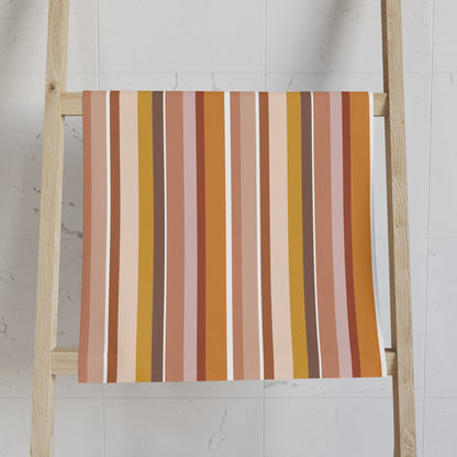 Striped towel on a wooden ladder against a white wall