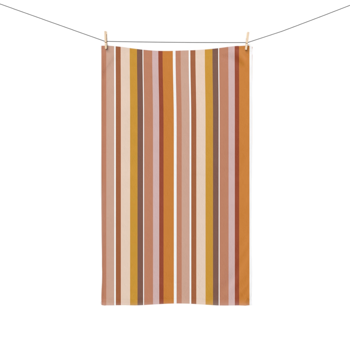 Striped towel with vertical brown, yellow, and pink stripes hanging on a line.
