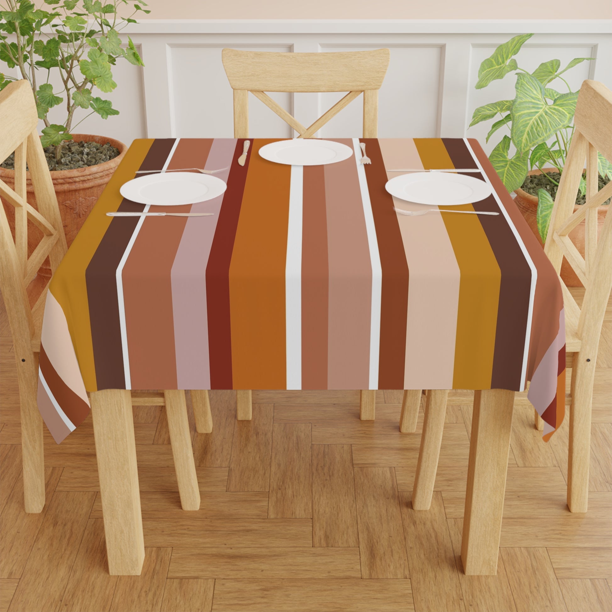 Dining table with a striped tablecloth on a wooden floor, surrounded by chairs.