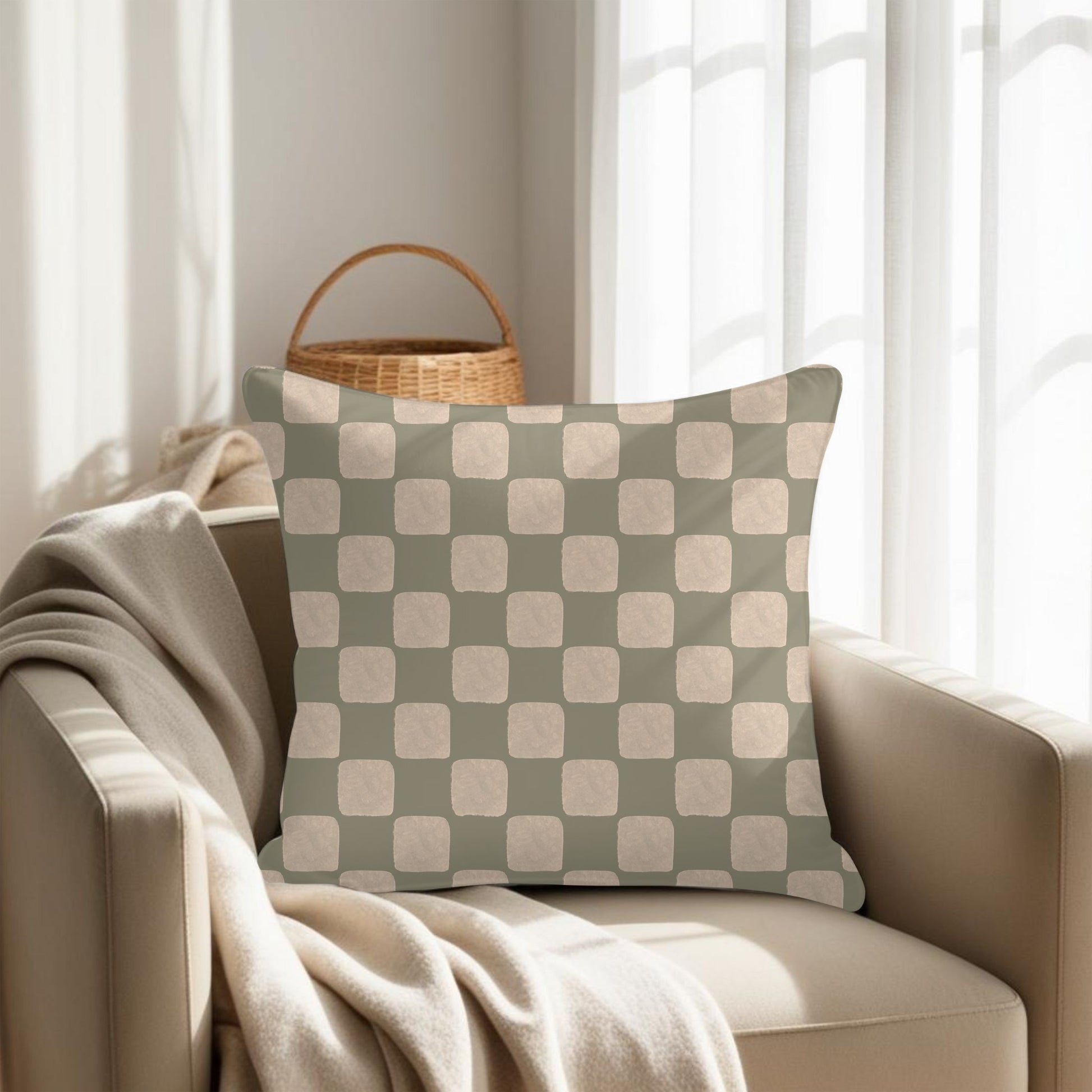 Checkered pillow on a beige armchair with a woven basket in the background