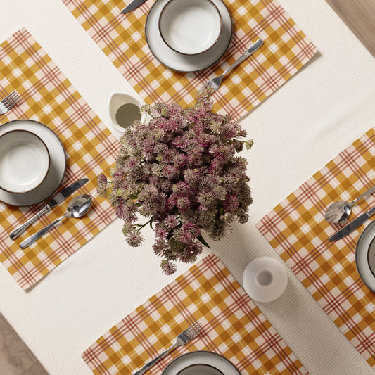 Table setting with checkered placemats, plates, and a floral centerpiece.