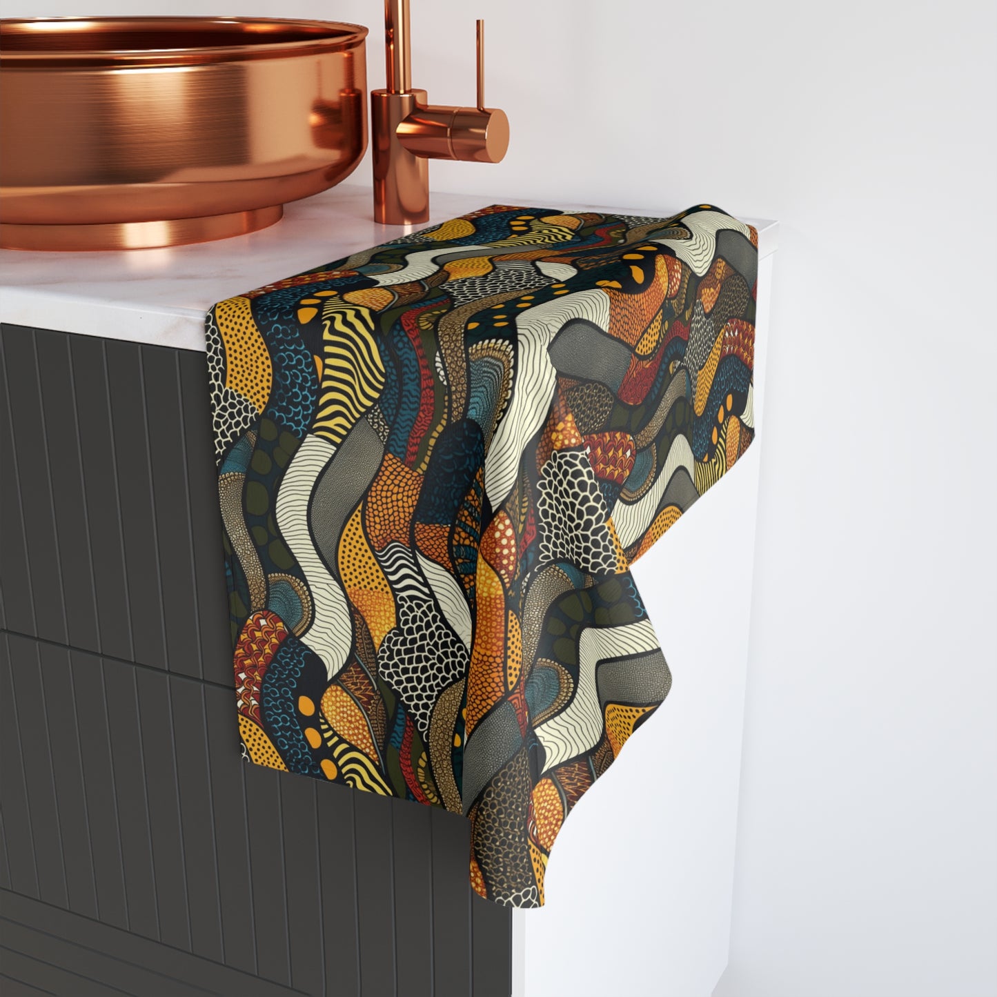 Colorful patterned towel draped over a bathroom faucet with copper fixtures.