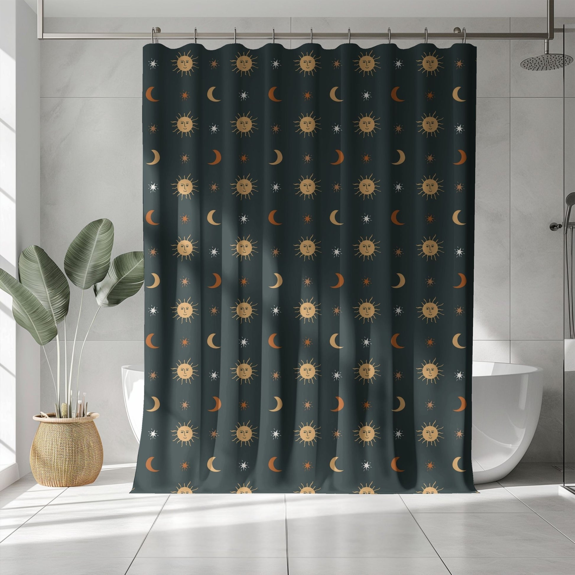 A dark teal shower curtain with a repeating celestial pattern of suns, moons, and stars, hanging in a modern bathroom with a white tub, tiled walls, and a potted plant.