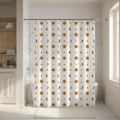 A white shower curtain with a repeating celestial pattern of yellow suns, orange crescent moons, and small blue stars, hanging in a bright, modern bathroom.