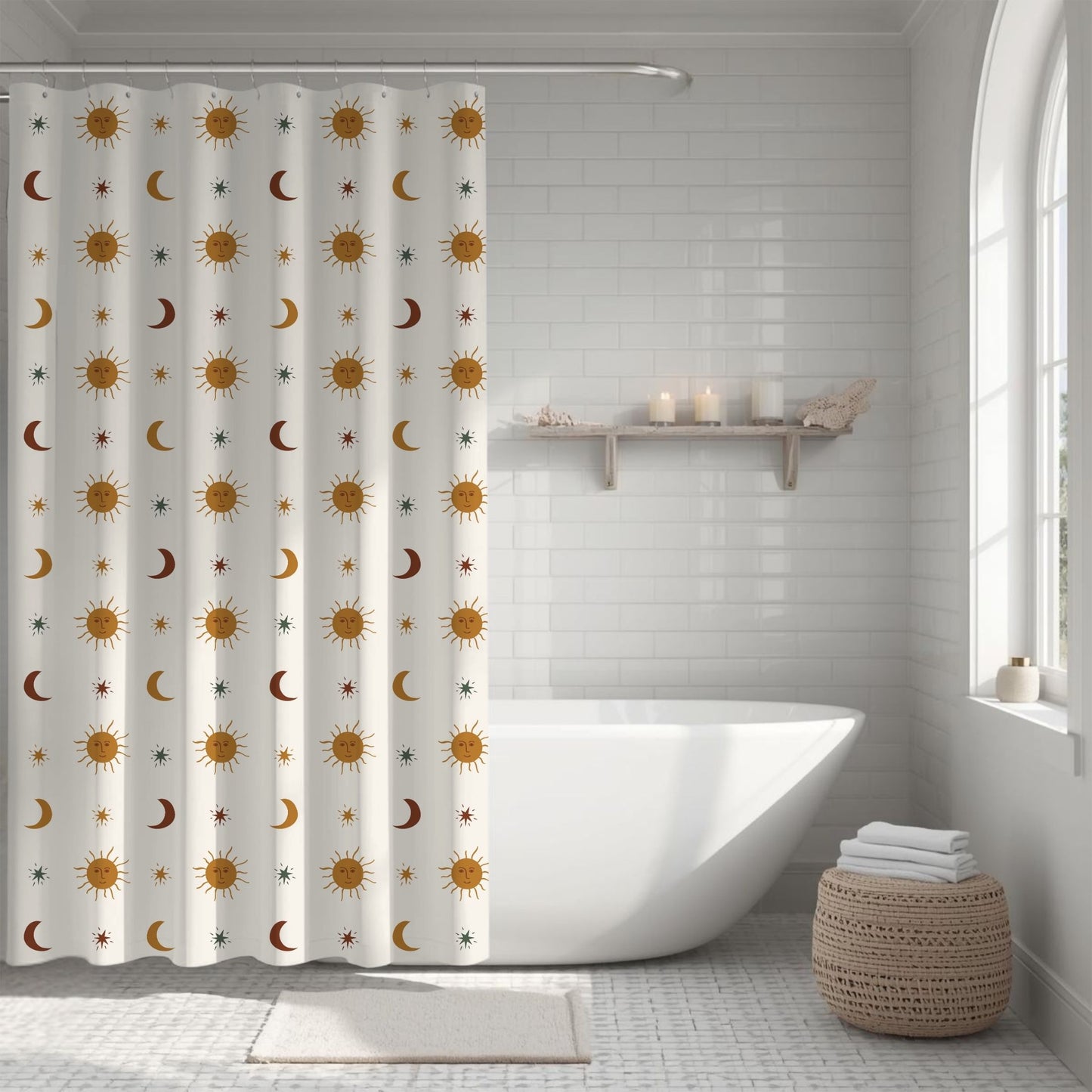 A white fabric shower curtain with a repeating pattern of gold suns, brown crescent moons, and small blue stars, hanging in a bright white tiled bathroom next to a freestanding bathtub.