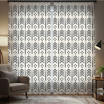 Living room with tribal patterned curtains, bookshelves, and a lamp.