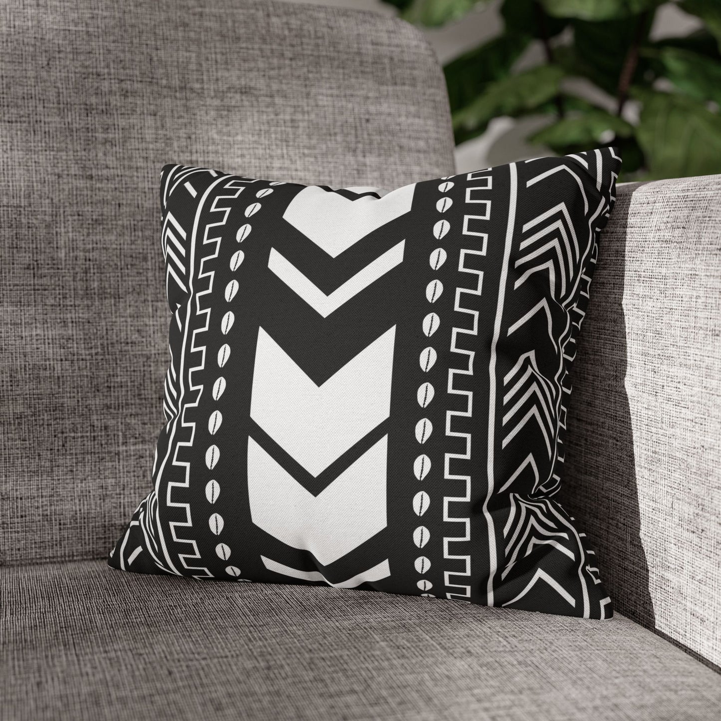 Mudcloth pillow with black and white pattern on a gray couch