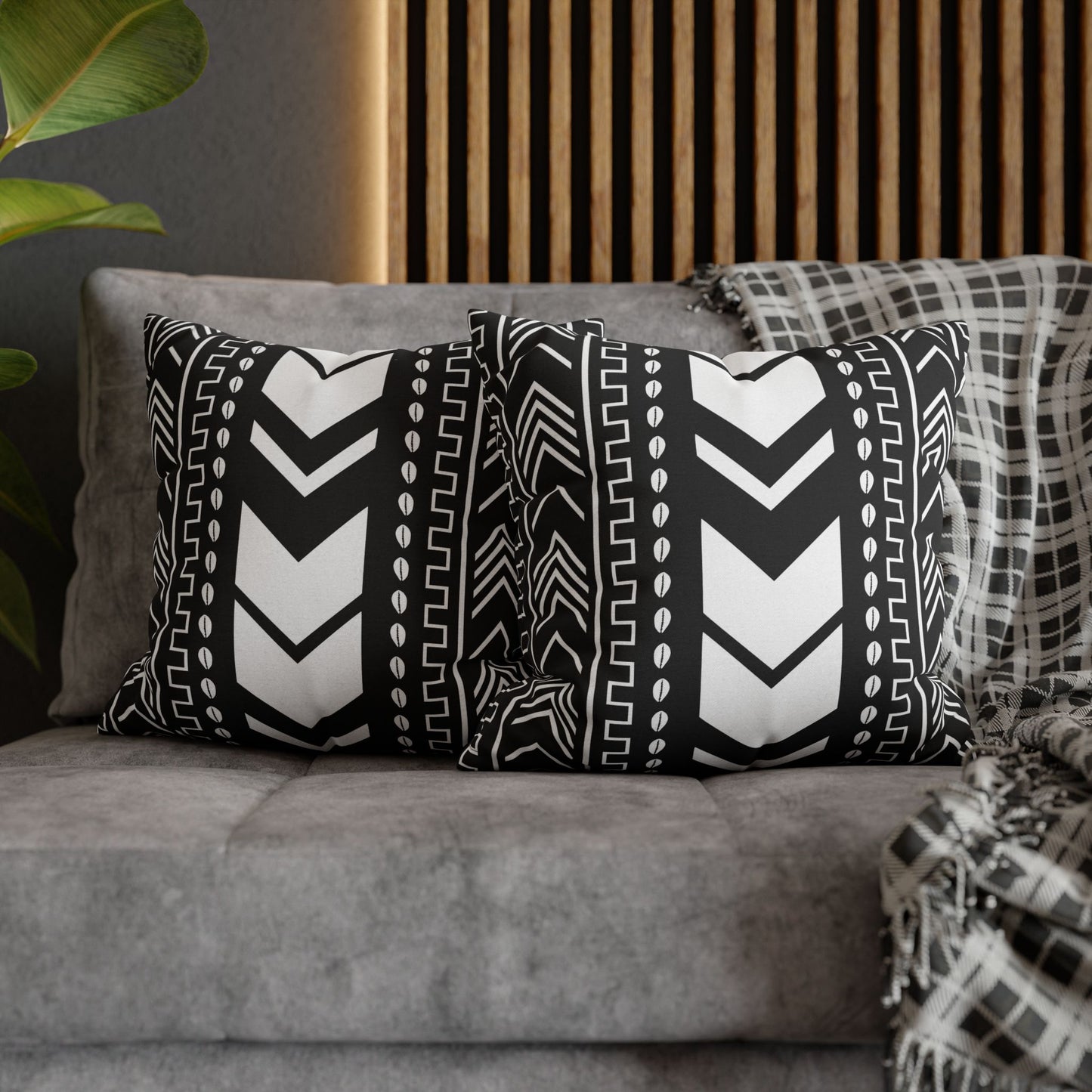 Tribal Print  pillows with black and white patterns on a gray sofa.