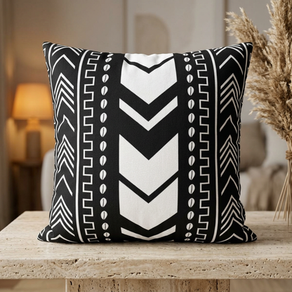 Black and white patterned pillow on a wooden surface with a blurred background