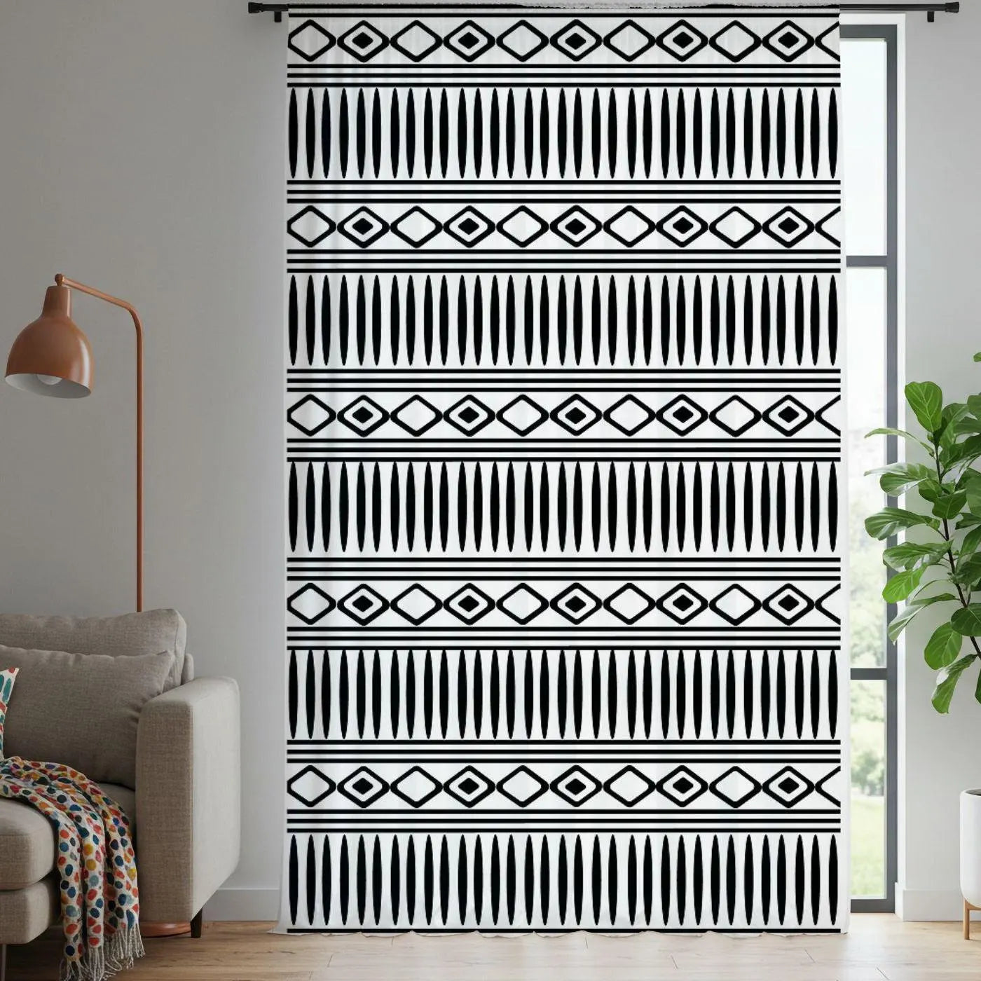 Patterned black and white curtain in a living room setting with a lamp and sofa.