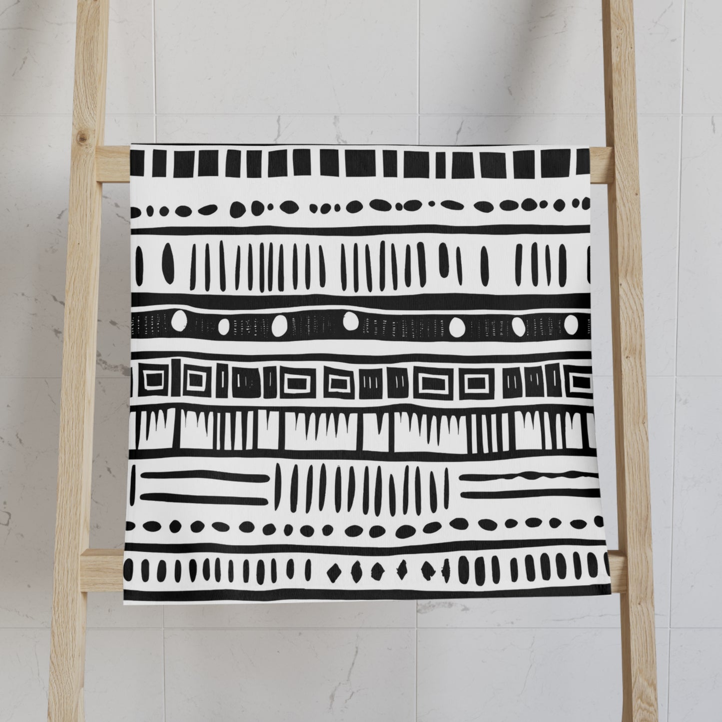 Black and white patterned towel on a wooden ladder against a light background