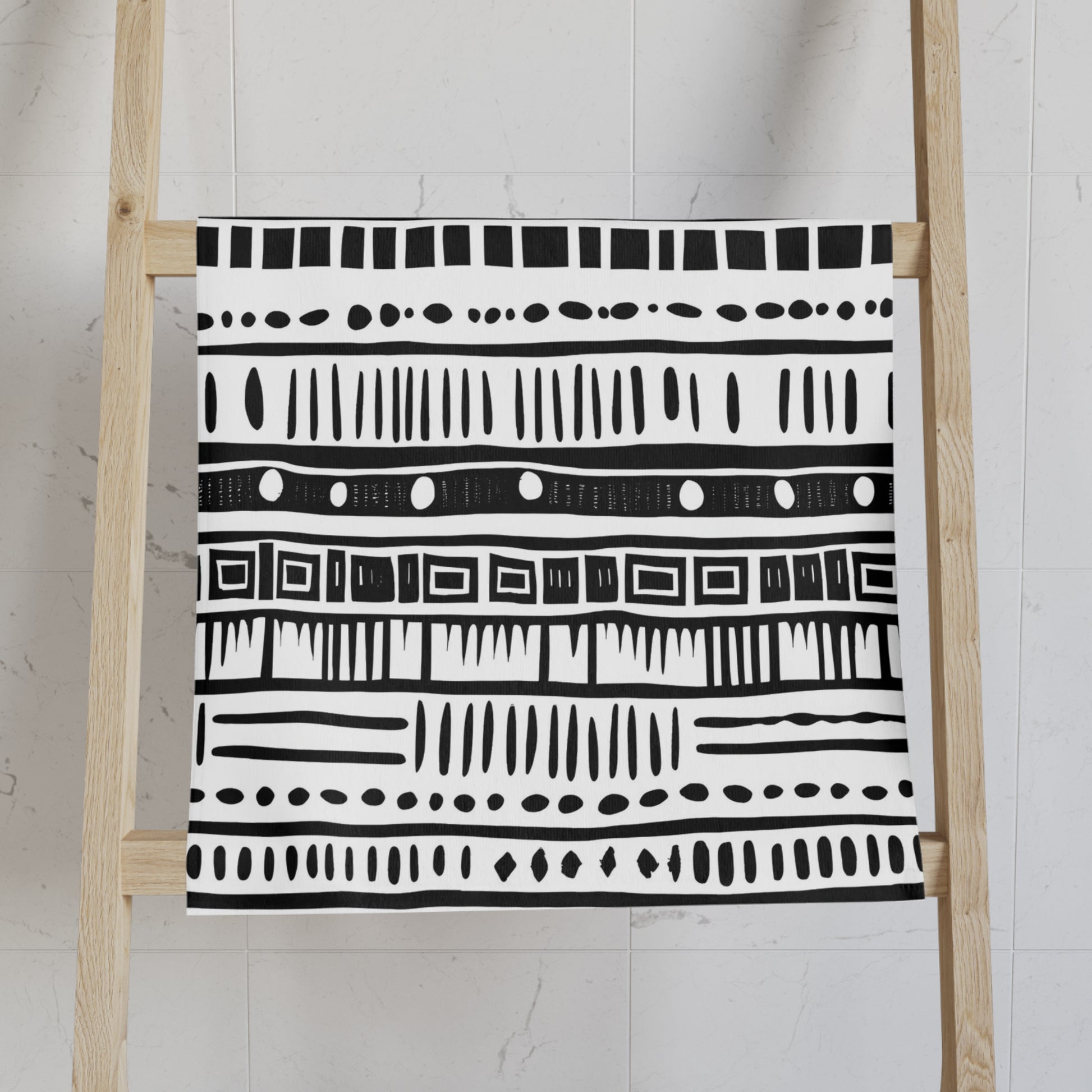 Black and white patterned towel on a wooden ladder against a light background