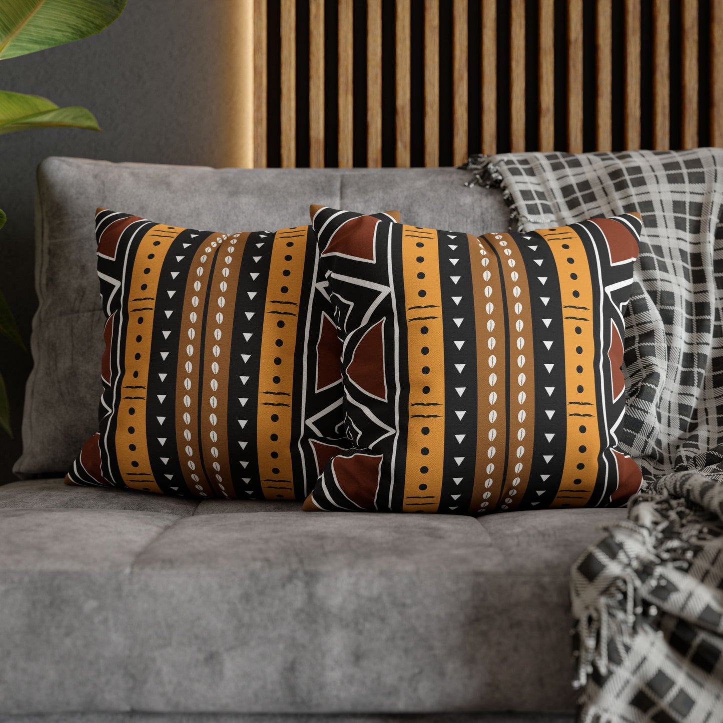 Mudcloth Decorative pillows with tribal patterns on a gray sofa.