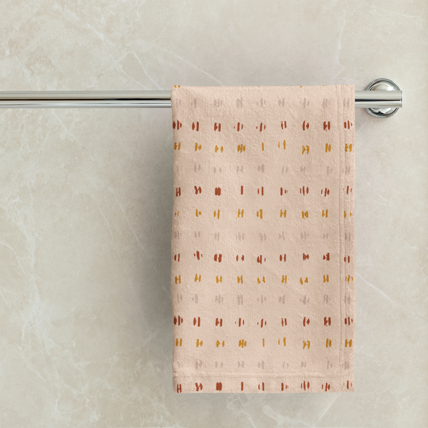 Patterned towel hanging on a towel rack against a marble wall.