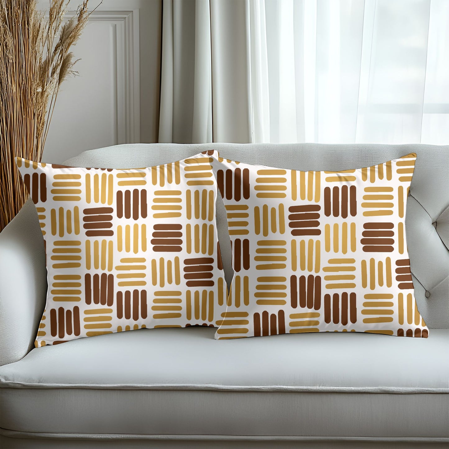 Two patterned pillows on a white sofa with a neutral background