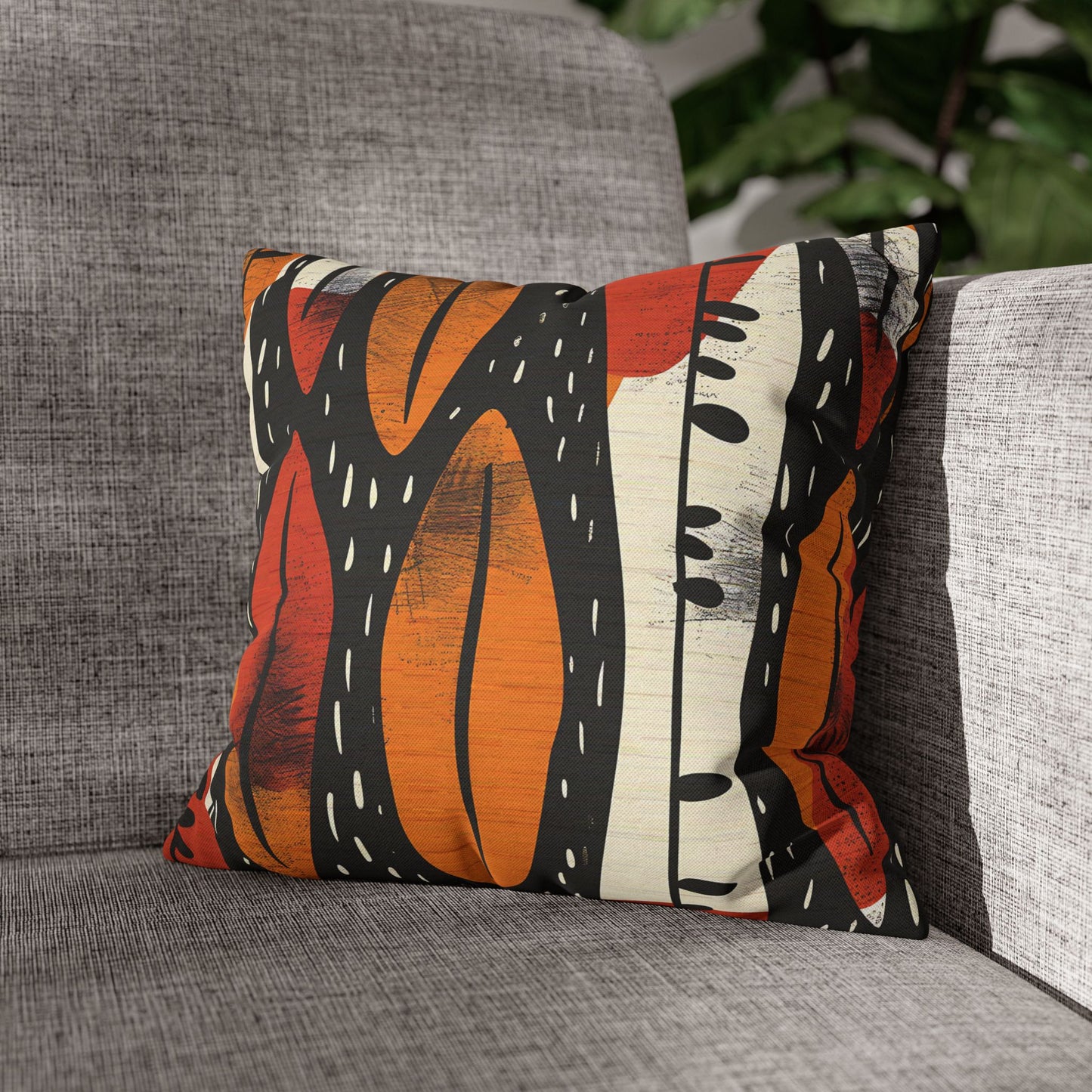 Decorative pillow with a colorful abstract pattern on a gray couch.