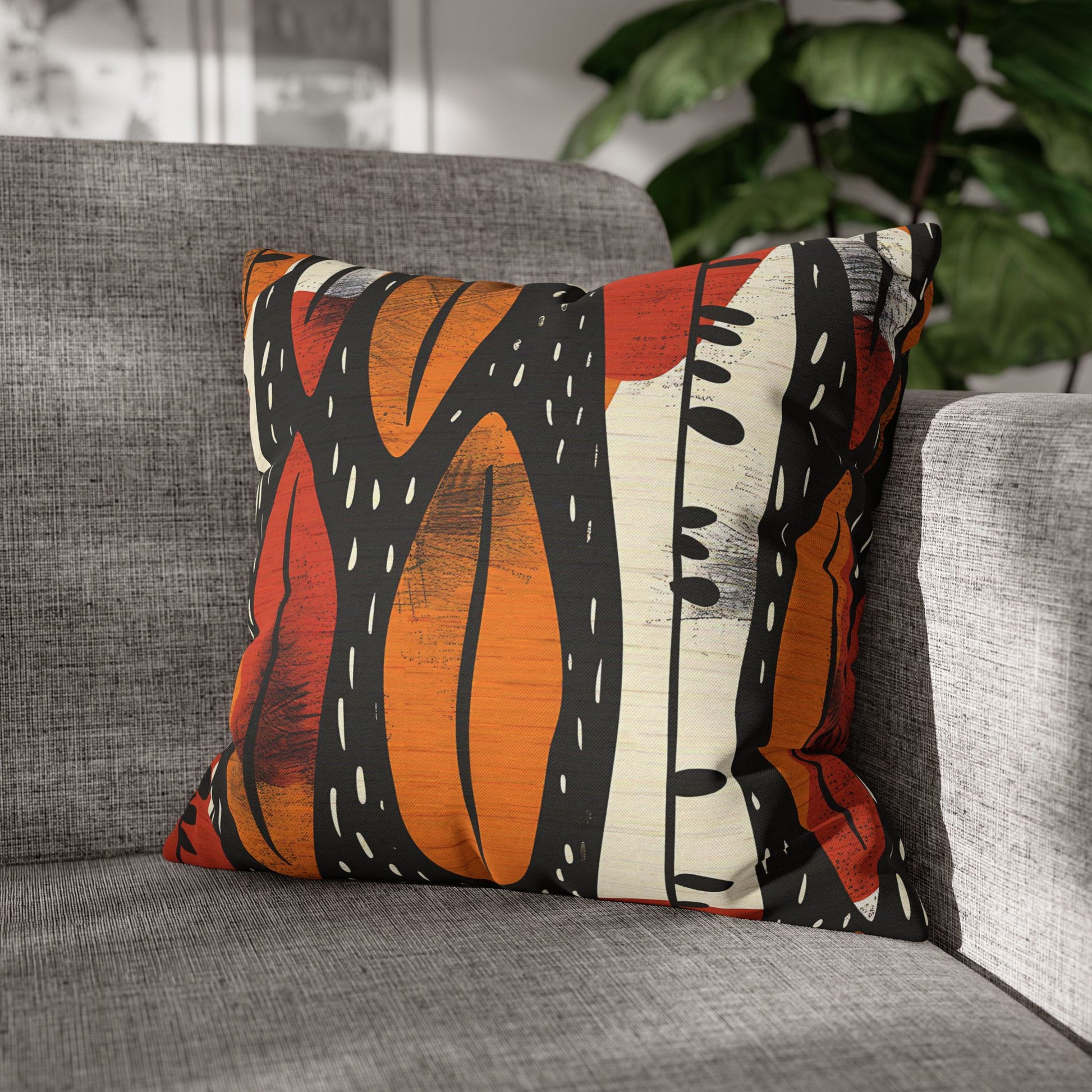 Decorative pillow with a colorful abstract pattern on a gray sofa.