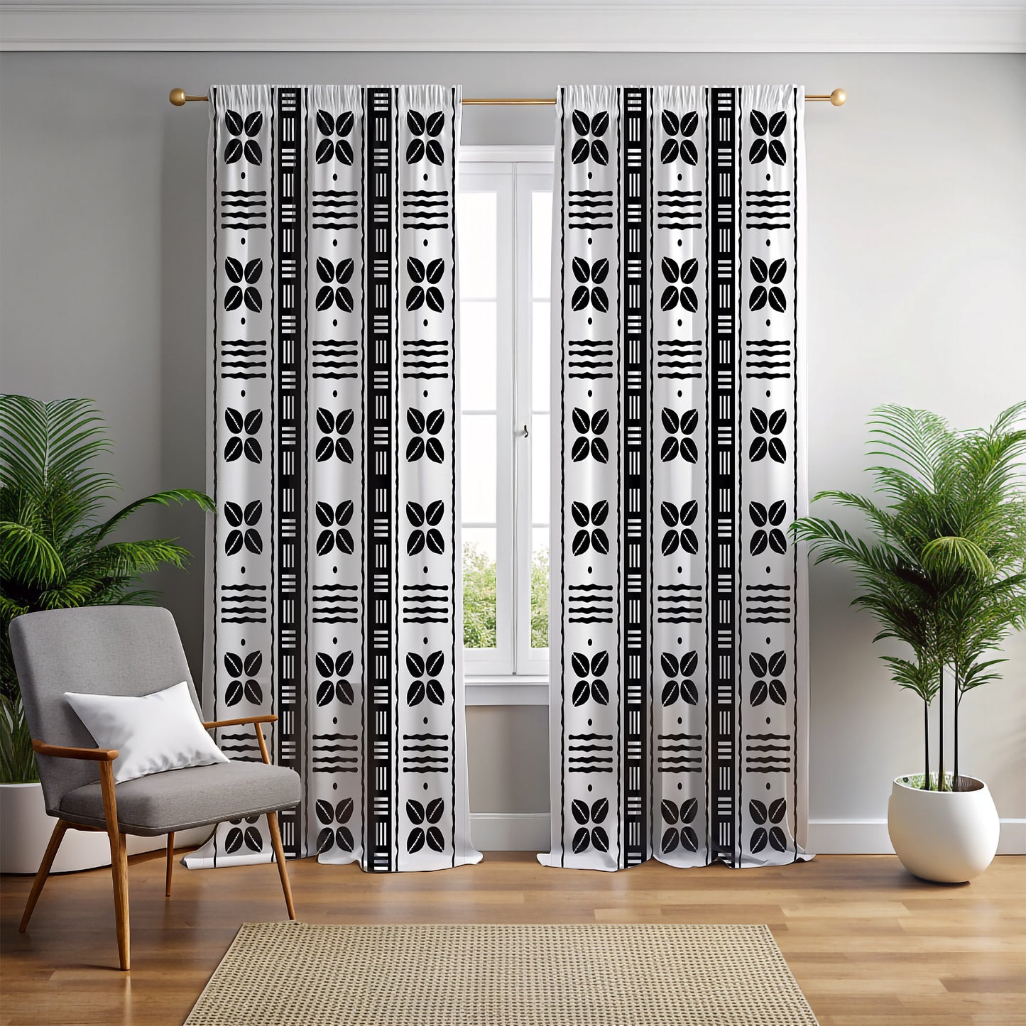 A pair of mudcloth-inspired blackout curtains featuring traditional Bogolan patterns and African shell motifs, hanging in a room with a chair and a plant.