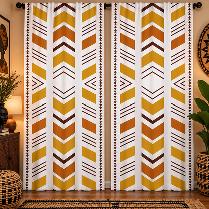 A pair of long window curtains hanging on a black rod in a styled room. The curtains feature a bold geometric pattern with yellow, orange, and brown chevron and triangle motifs on a white background, flanked by narrow vertical bands of small black triangles.