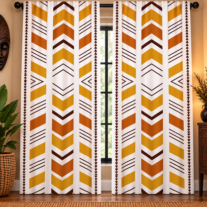 A pair of long window curtains hanging in a room, featuring a bold geometric chevron pattern in mustard yellow, orange, and dark brown on a white background.