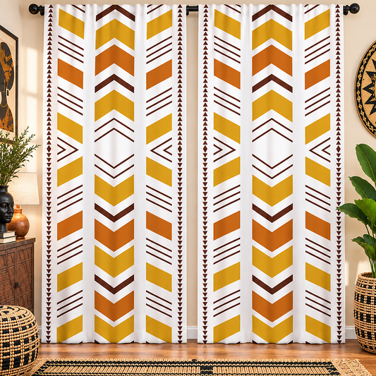 A pair of long curtain panels hanging in a styled room. The curtains have a bold geometric pattern of vertical chevron stripes in yellow, orange, and brown on a white background.