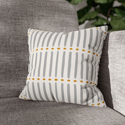 Striped pillow with yellow dots on a gray couch