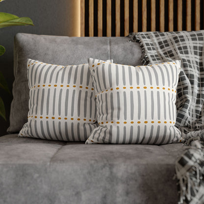 Two patterned cushions on a gray sofa with a wooden headboard in the background.