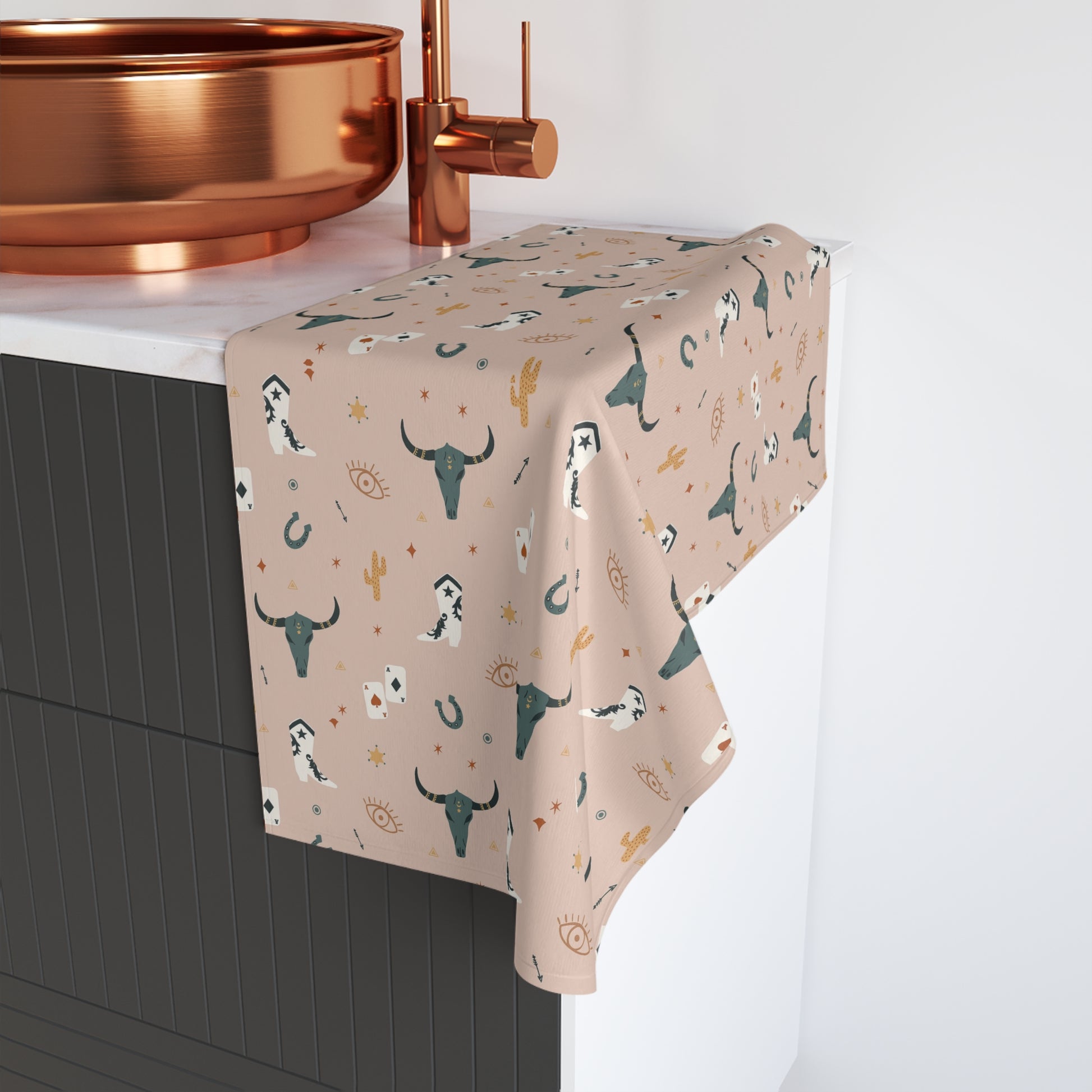 Decorative hand towel with wild west pattern hanging over a sink