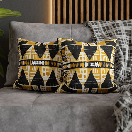 Two patterned pillows on a gray sofa with a wooden headboard in the background.