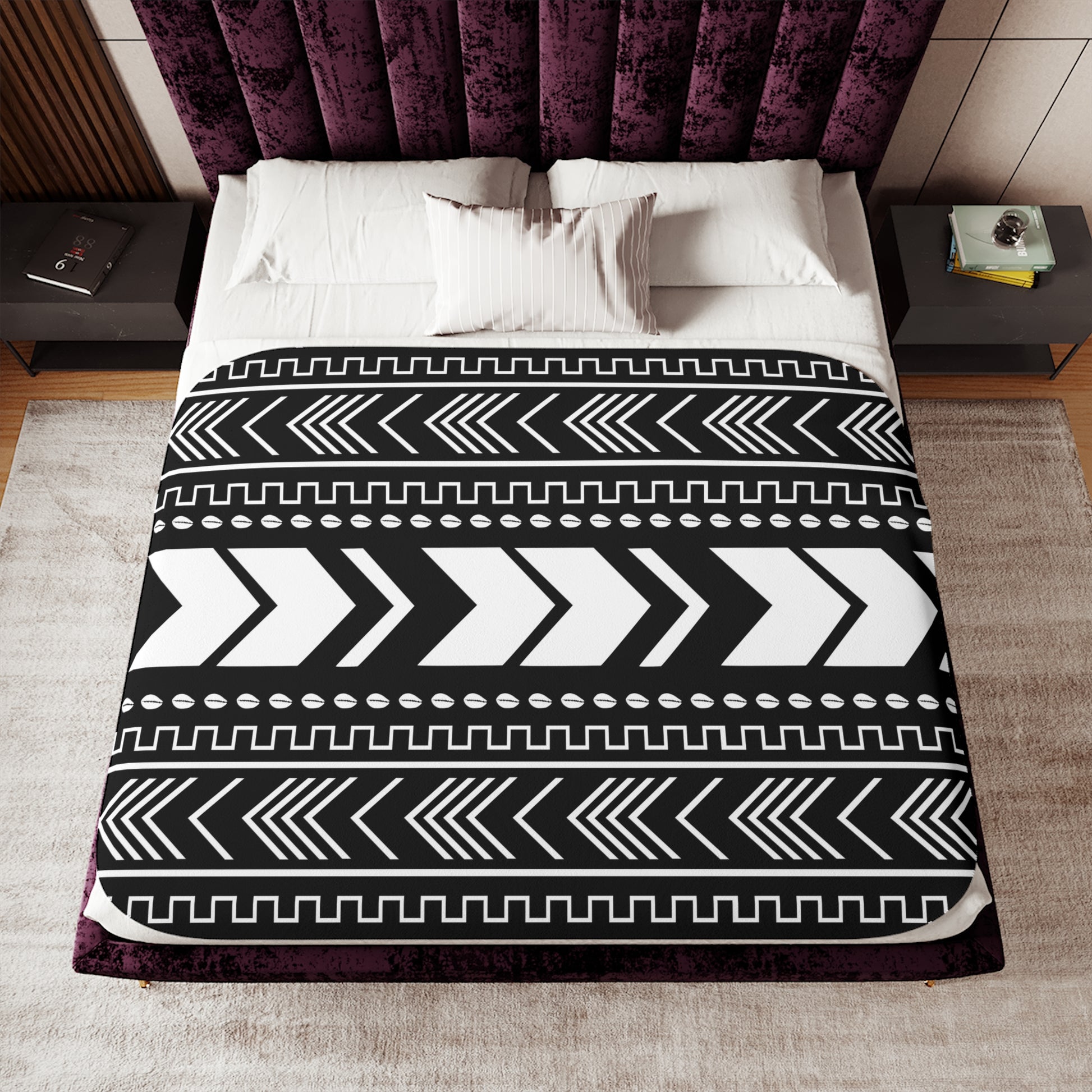 Bed with a black and white patterned comforter in a bedroom setting.
