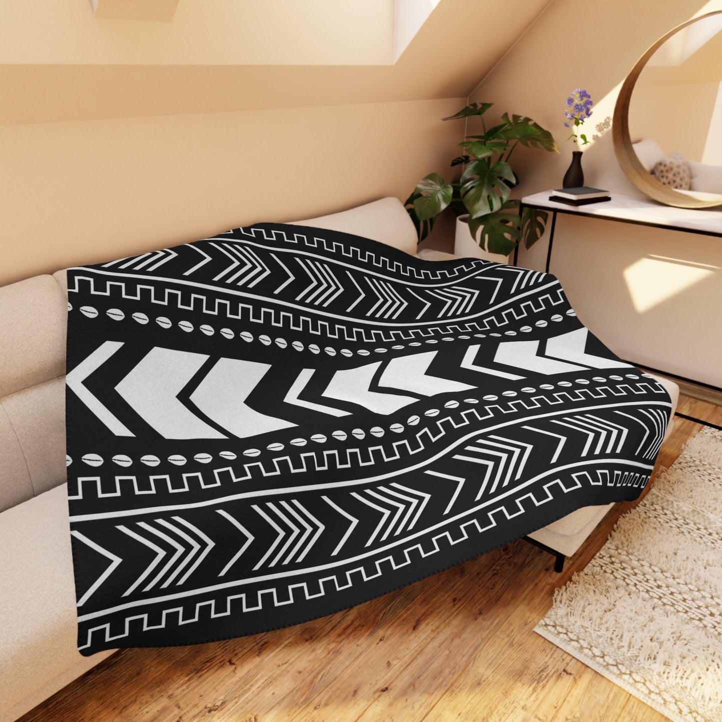 Black and white patterned throw blanket on a couch in a cozy living room.
