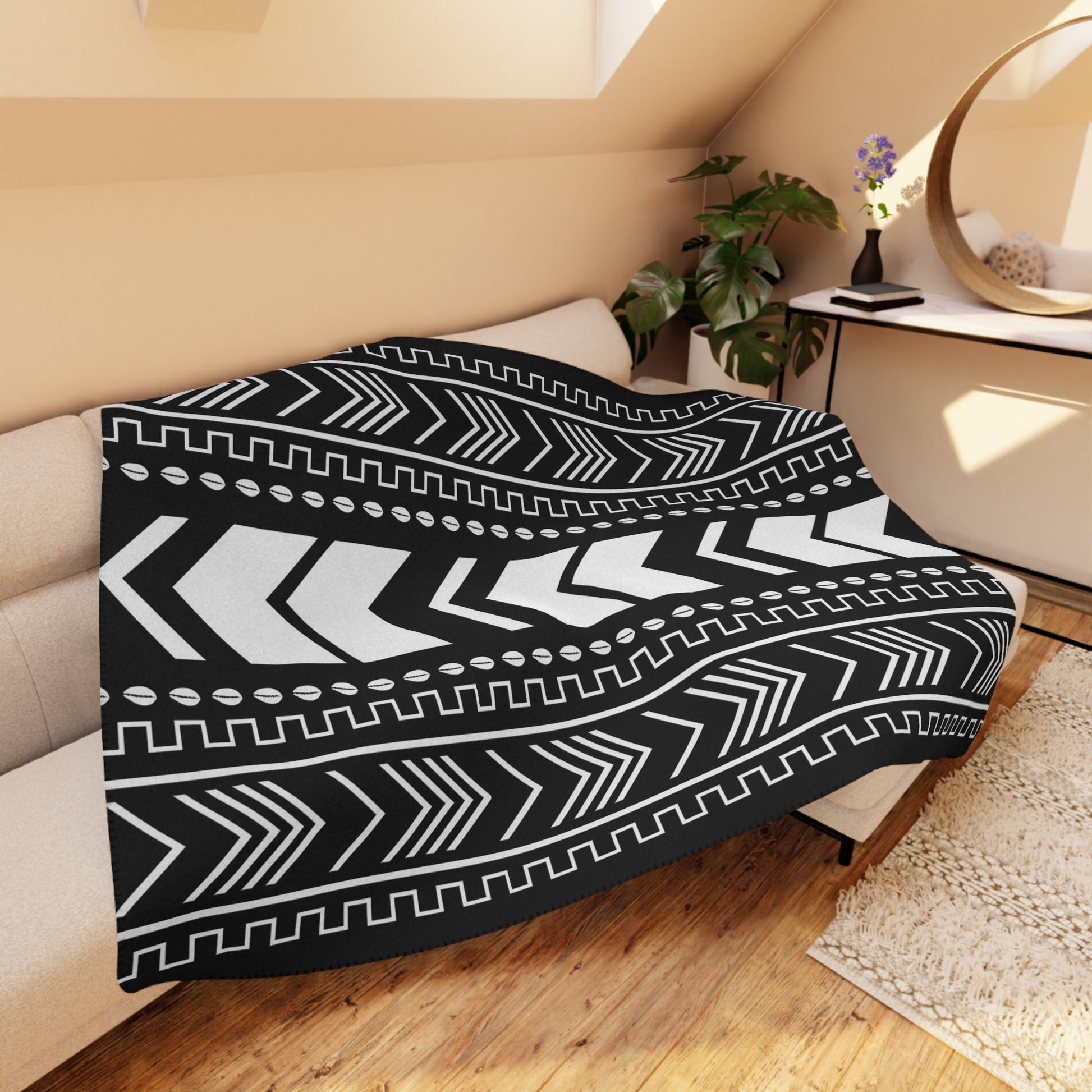 Black and white patterned throw blanket on a couch in a cozy living room.