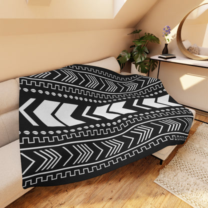 Black and white patterned throw blanket on a couch in a cozy living room.