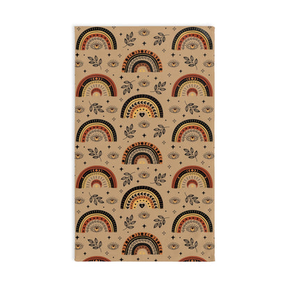 Beige evil eye towel with rainbow and leaf pattern on a white background