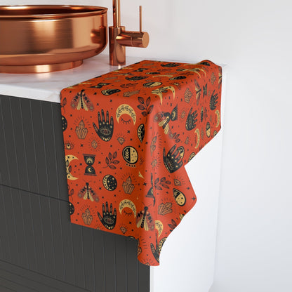 Hamsa patterned towel draped over a sink with a copper faucet.