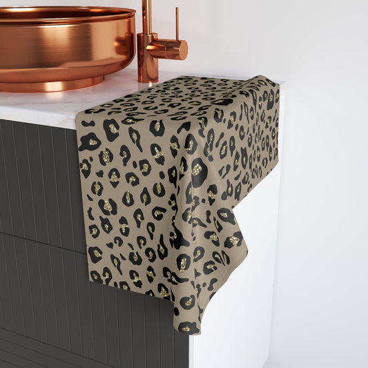 A leopard print towel with black and gold glitter patterns, draped over the edge of a counter.